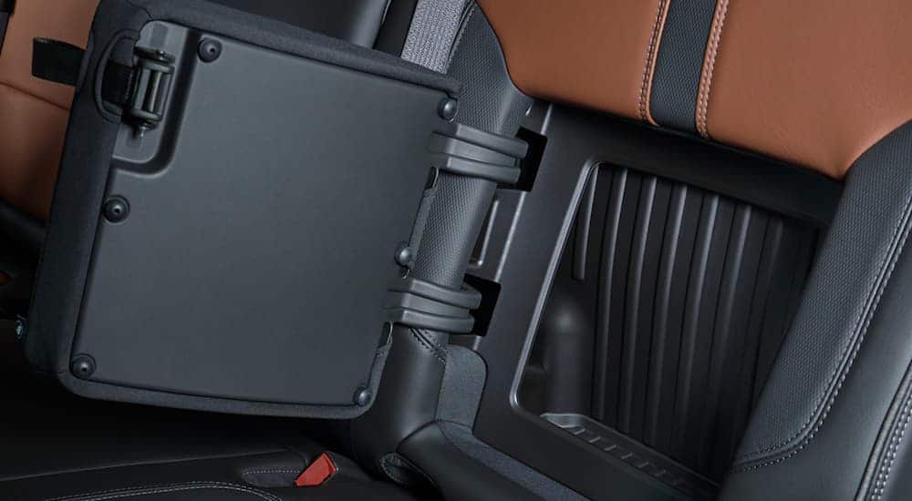 The tan and black interior and back seat storage is shown on a 2021 Chevy Silverado 1500.