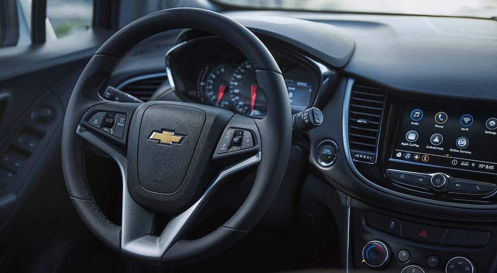 The black steering wheel and information cluster is shown in a 2021 Chevy Trax.