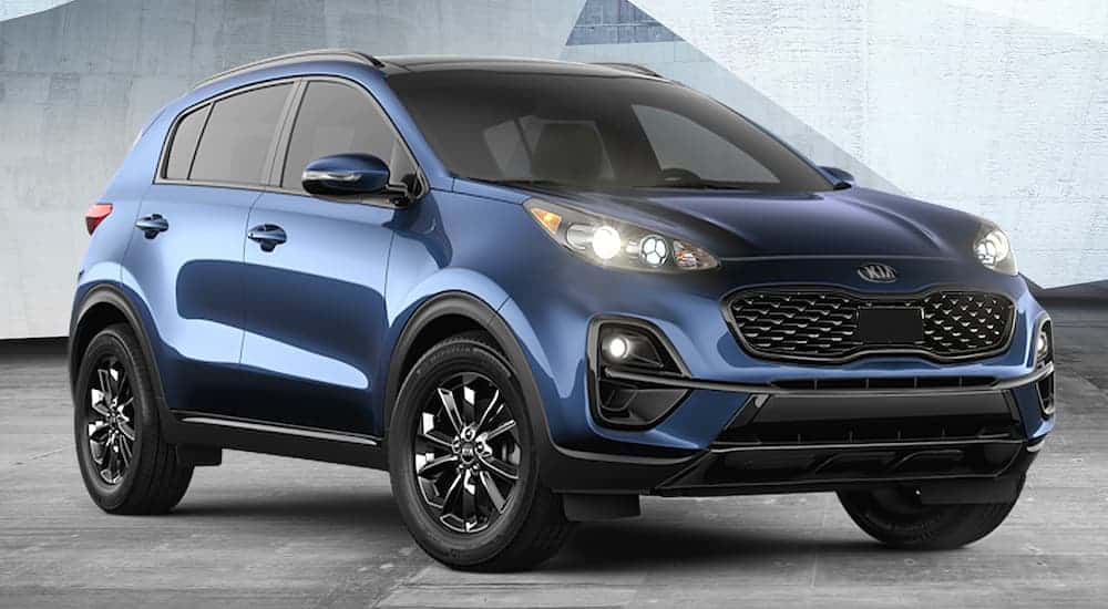 A blue 2021 Kia Sportage Nightfall Edition is shown from the front angled right parked on the concrete.