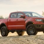 A red 2021 Ford Ranger Tremor is parked in an open dirt area.