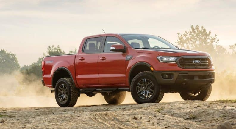 A red 2021 Ford Ranger Tremor is parked in an open dirt area.