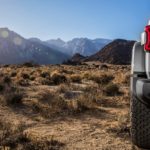 The rear taillight of a 2021 Jeep Wrangler 4xe is shown in closeup with mountains in the distance.