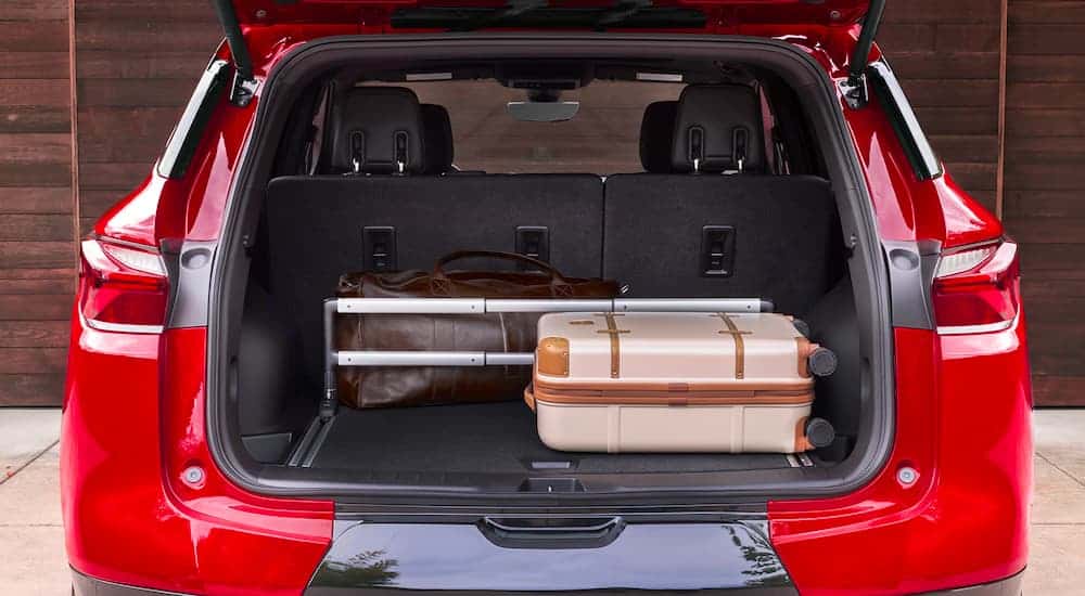 A red 2021 Chevy Blazer is shown from the rear with luggage in the trunk.