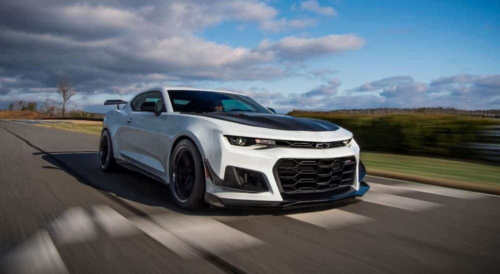 A white 2021 Chevy Camaro ZL1 is driving on a race track.