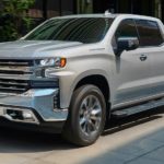 A grey 2021 Chevy Silverado 1500 is parked in front of a store angled left.