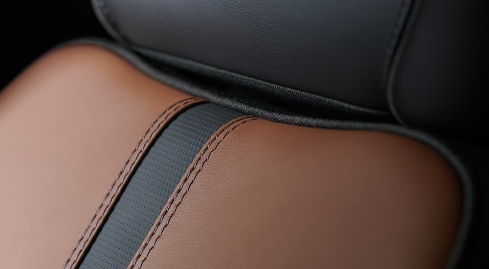 The brown and black leather interior is shown with a close up of the stitching on a 2021 Chevy Silverado 1500.