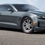 A grey 2021 Chevy Camaro 1LS coupe is parked on the pavement angled right after leaving the Chevy dealer.
