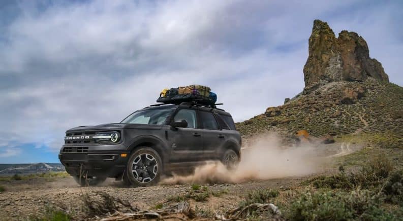 A grey 2021 Ford Bronco Sport Outer Banks is driving past a rock formation after leaving a Ford Bronco dealer in Canon City.