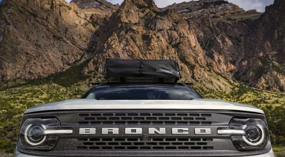 A silver 2021 Ford Bronco Sport is shown from the front at a low angle with mountains in the background.