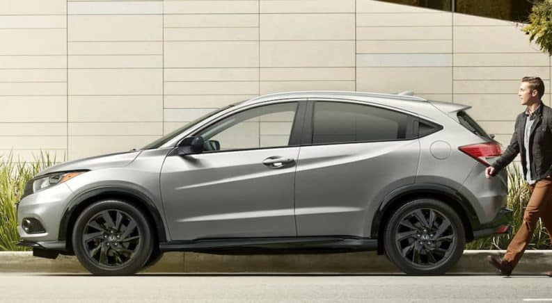 A silver 2021 Honda HR-V is shown in profile with a man approaching it from behind.