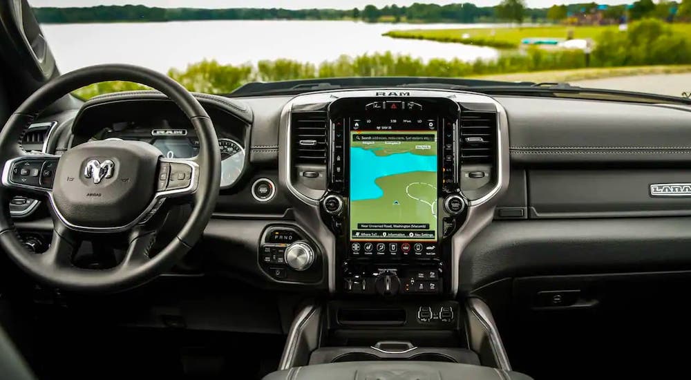 The interior dashboard of a 2021 Ram 1500 Laramie is shown while overlooking a pond.