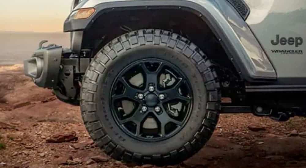 The wheel and bumper on a silver 2018 Used Jeep Wrangler Moab is shown in closeup.
