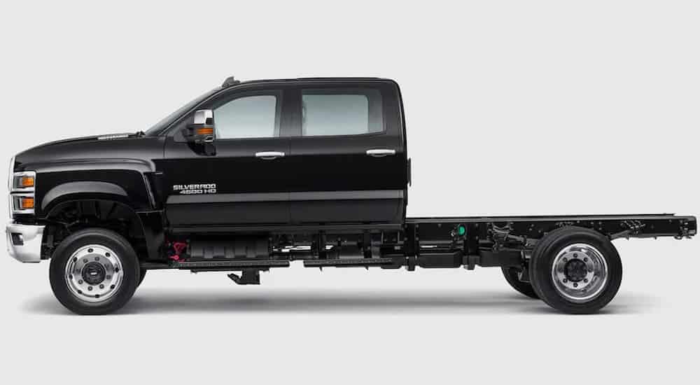 A black 2021 Chevy Silverado 4500 Chassis Cab is shown from the side from the side against a gray background.