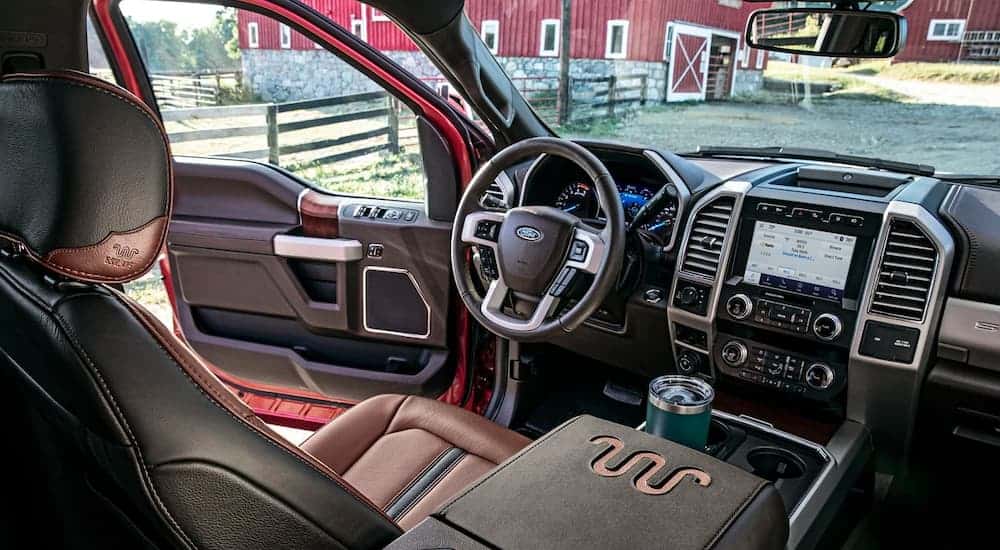 The black and brown interior is shown from the back seat on a 2021 Ford Super Duty King Ranch.