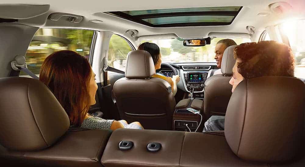 The tan interior is shown from the rear with a family in a 2021 Nissan Murano.