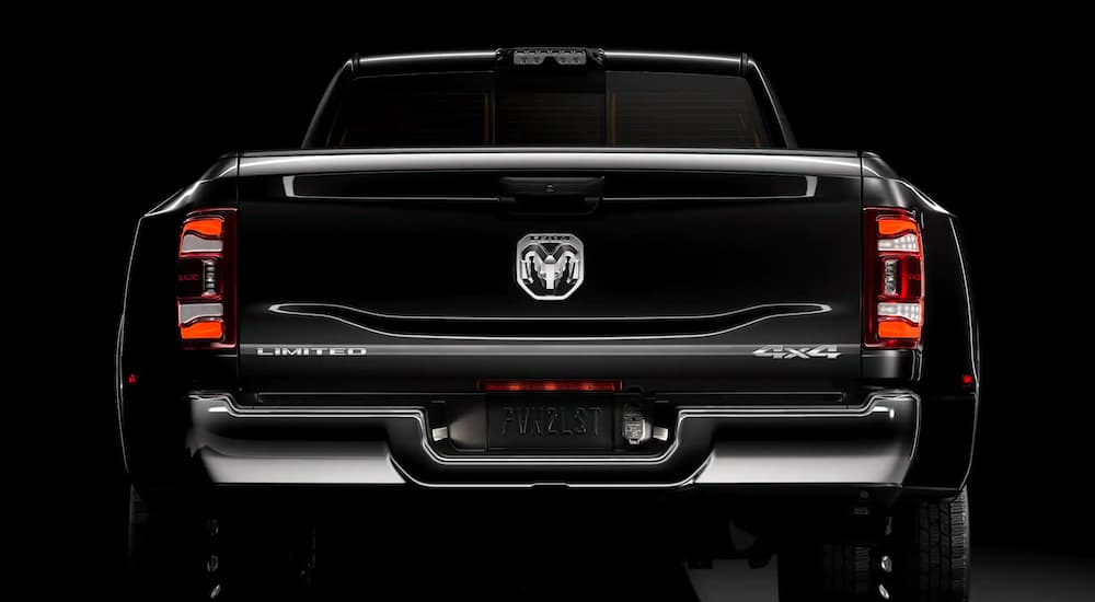 A close up is showing the rear LED tail lights on a black 2021 Ram 3500, against a black background.