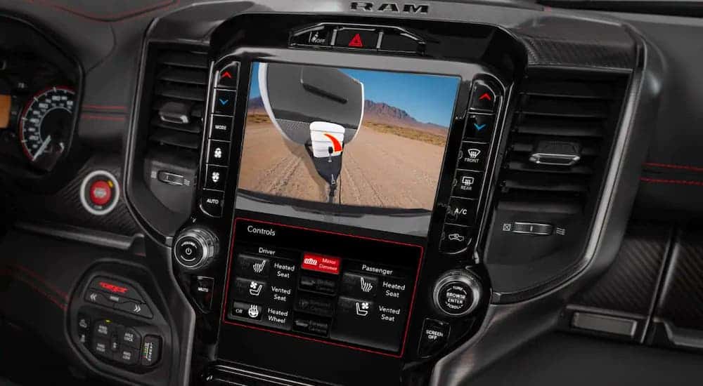 The infotainment screen in a 2021 Ram 1500 is shown with a backup camera and trailer.