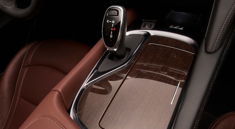 A close up shows the center console and woodgrain finish on a 2019 used Buick Enclave Avenir.