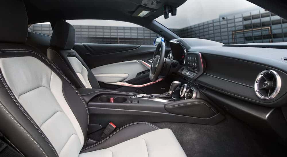 The black and white interior on a 2021 Chevy Camaro 3LT is shown through the passenger door.