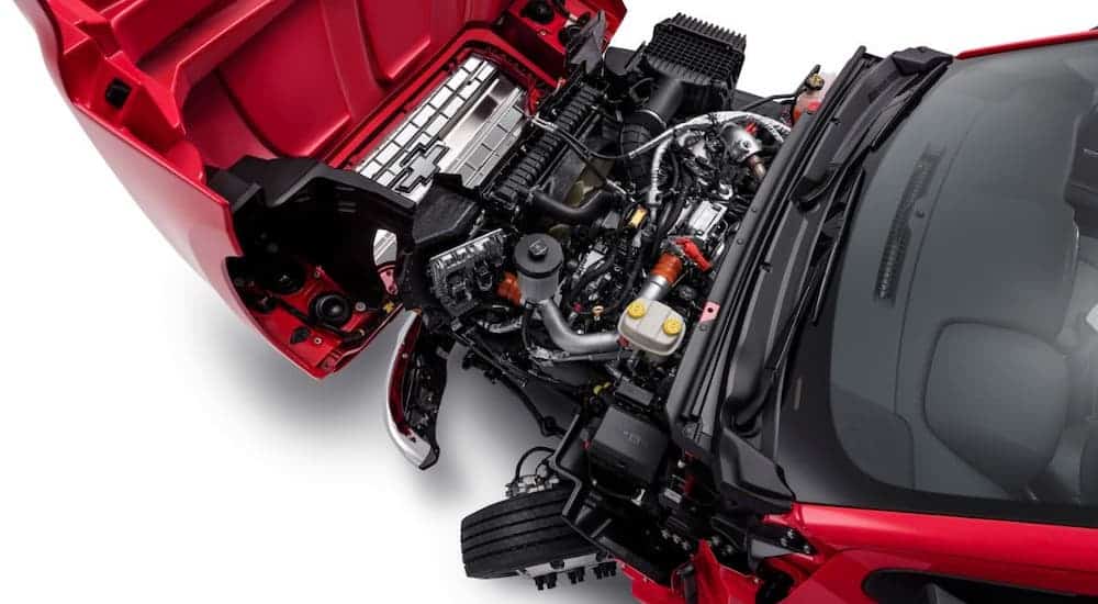 A top-down view shows the clamshell hood on a red 2021 Chevy Silverado 5500 against a white background.
