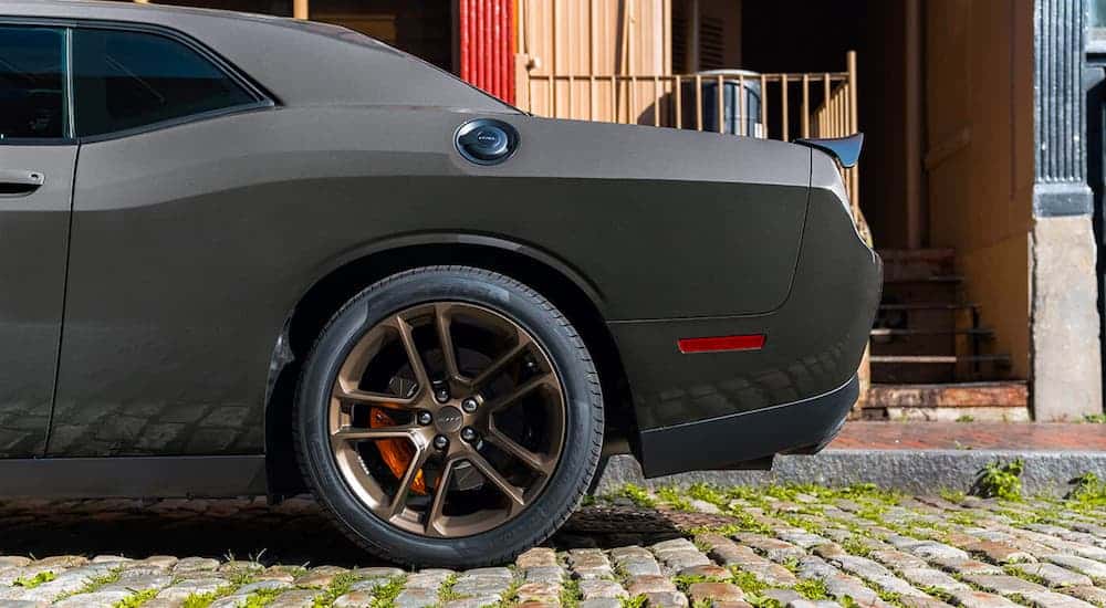 A close up shows the bronze rear wheel of a dark gray 2021 Dodge Challenger.