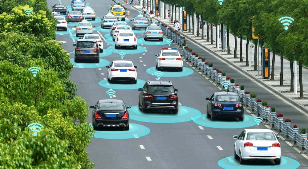 A rendering is shown of autonomous cars driving down a 3 lane road.