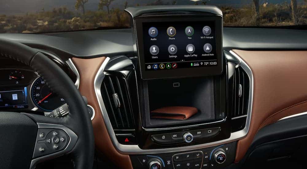 A close up is shown of the infotainment system and hidden cubby on a 2021 Chevy Traverse.