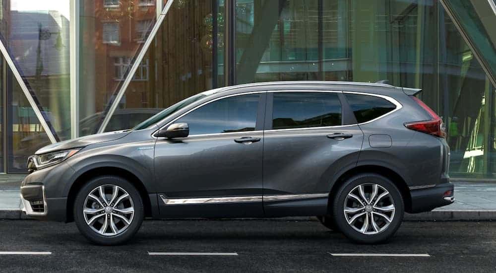 A grey 2021 Honda CR-V is shown from the side on a city street after leaving a Honda CR-V dealer.
