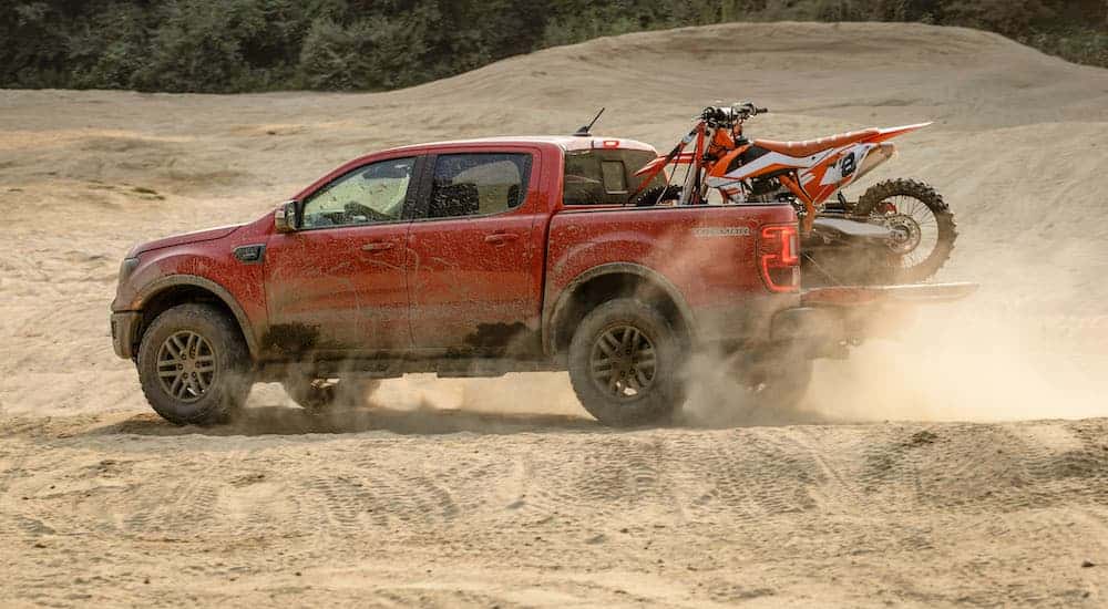 A red 2021 Ford Ranger Tremor Lariat is shown from the side with a dirt bike in the bed after leaving the NY Ford dealer.