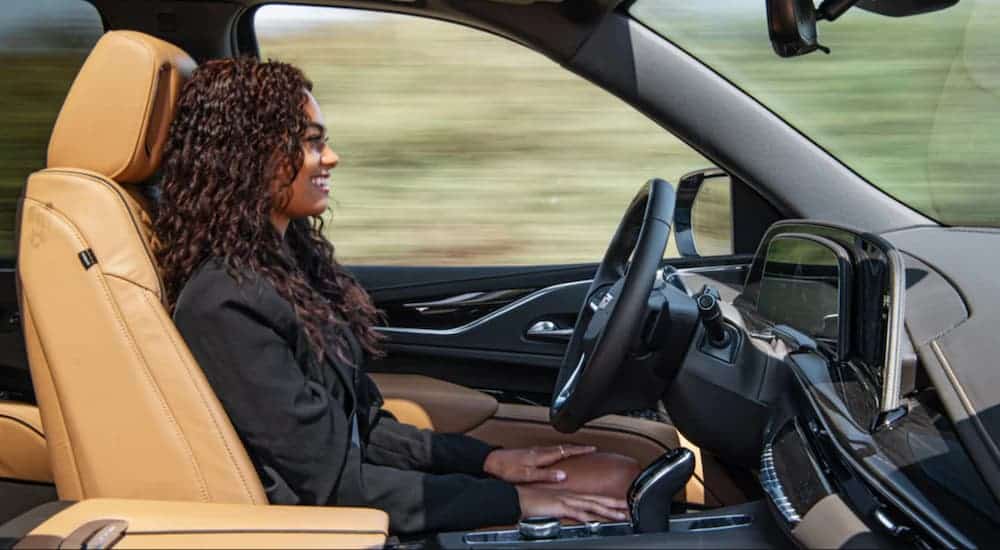 A woman is hands-free in the driver's seat of a GM vehicle using SuperCruise.