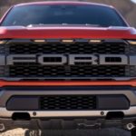 A closeup shows the grille on a red 2021 Ford F-150 Raptor.
