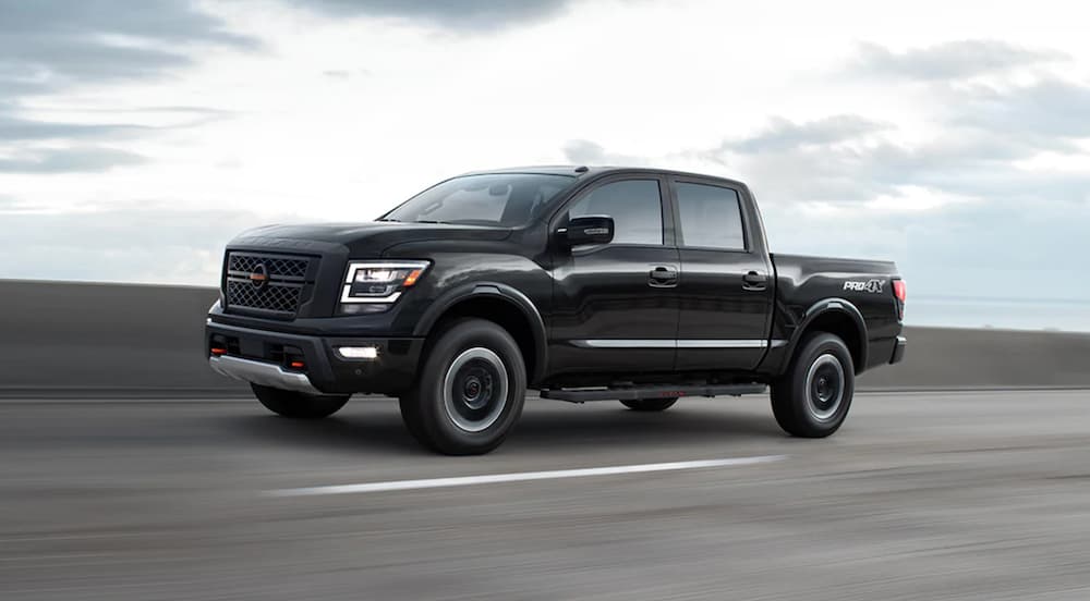 A black 2021 Nissan Titan is driving on a highway.