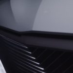 A closeup shows the headlight and hood of a gray Cadillac Celestiq.