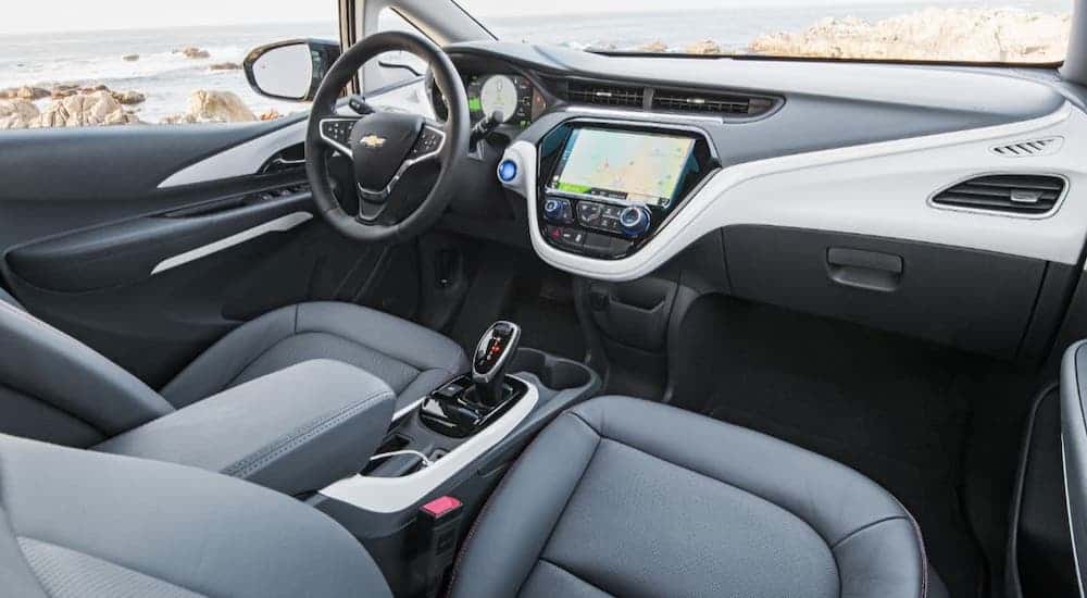 The black seats and gray dashboard in a 2021 Chevy Bolt EV are shown from the passenger's seat.