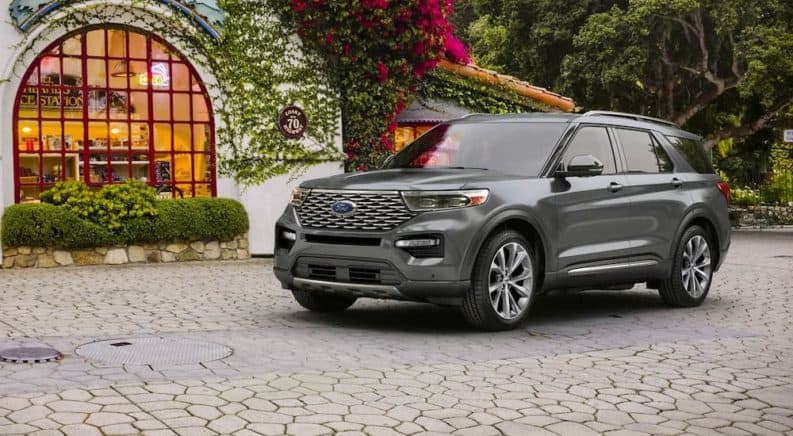 A gray 2021 Ford Explorer Platinum is parked in front of a building covered in ivy.