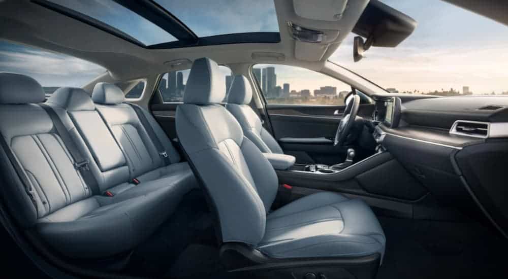 The white interior of a 2021 Kia K5 from a Kia dealership is shown.