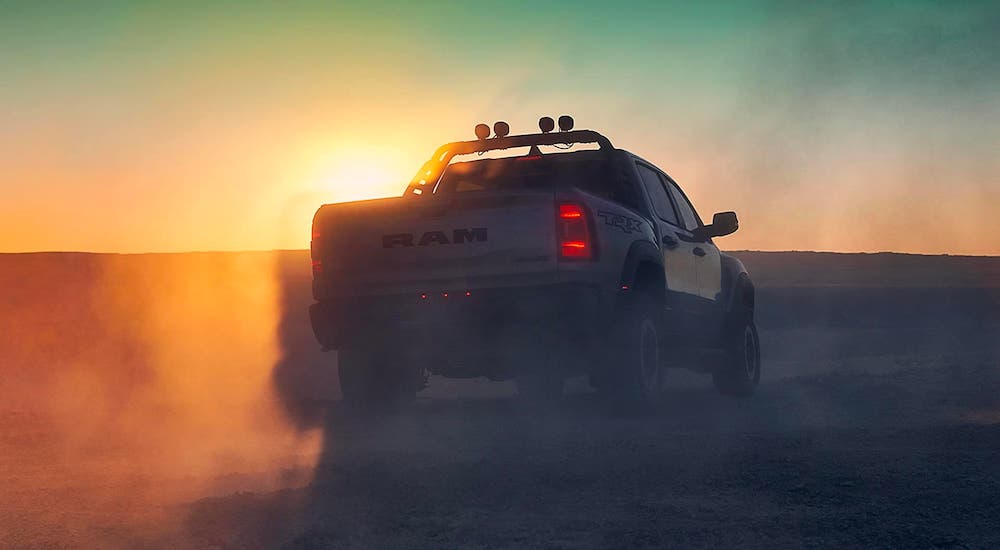 The silhouette of a 2021 Ram TRX is shown from the rear at sunset.