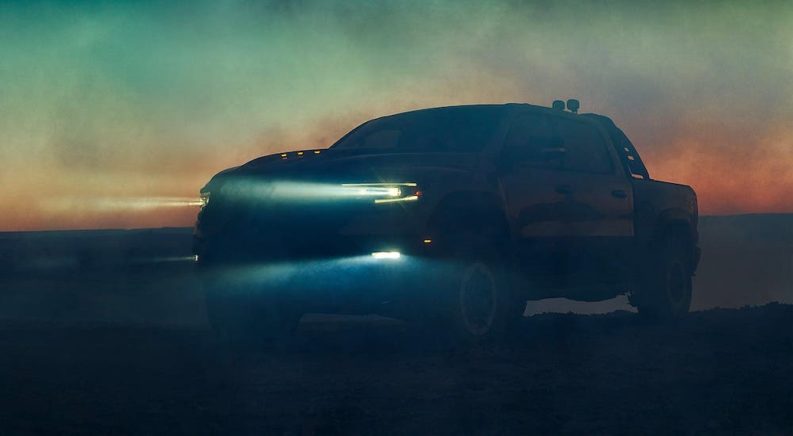 A silhouette of a 2021 Ram TRX is shown against a sunset.