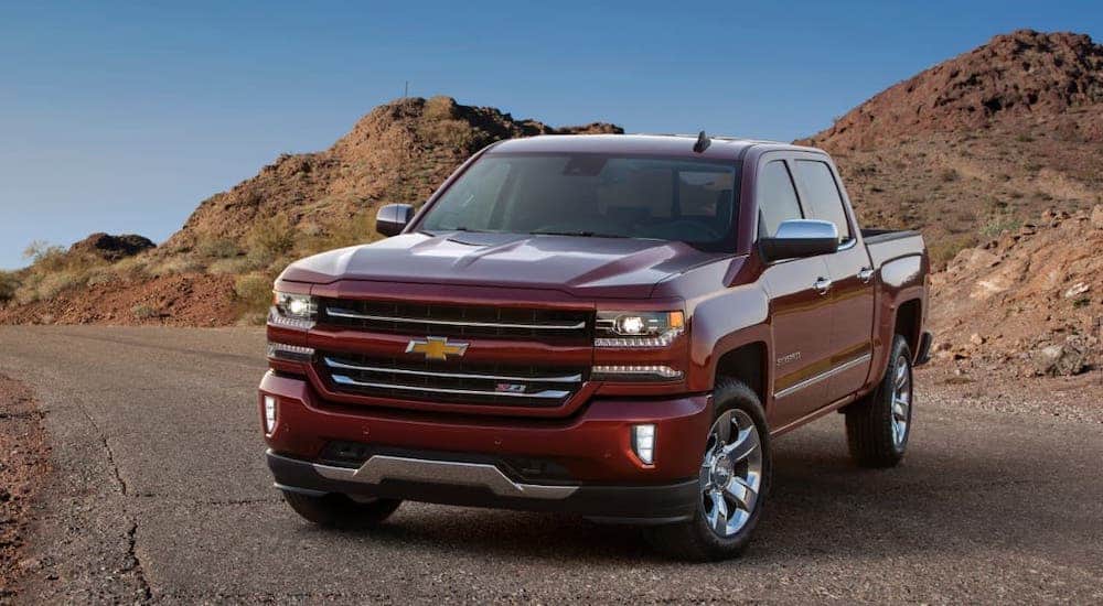 A red 2017 Chevy Silverado 1500 is parked on a rocky highway.