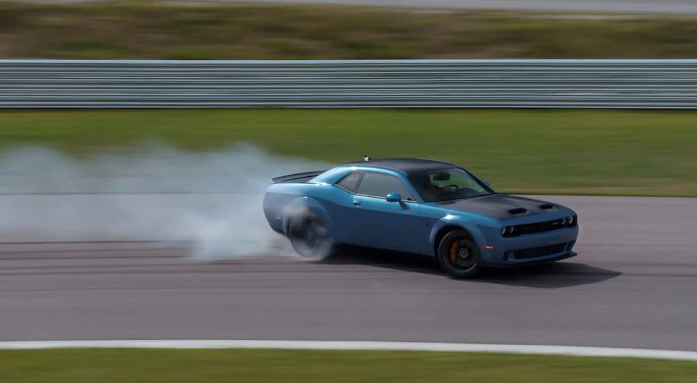 A blue 2020 used Dodge Challenger is drifting on a race track.