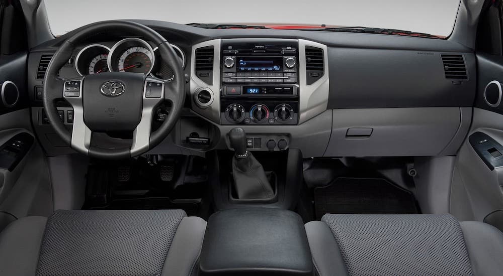 The gray and black interior and dashboard of a 2015 Toyota Tacoma is shown.