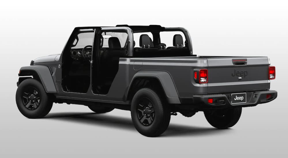 A grey 2020 used Jeep Gladiator Sport is shown from the rear with no top or doors on a white background.