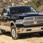 A black 2018 Ram 1500 is driving on a dirt road after leaving a used Ram dealer.
