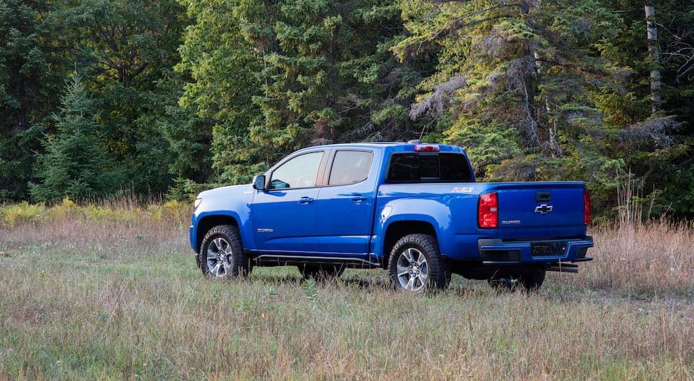 A blue 2021 Chevy Colorado Z71 is parked in a empty field.