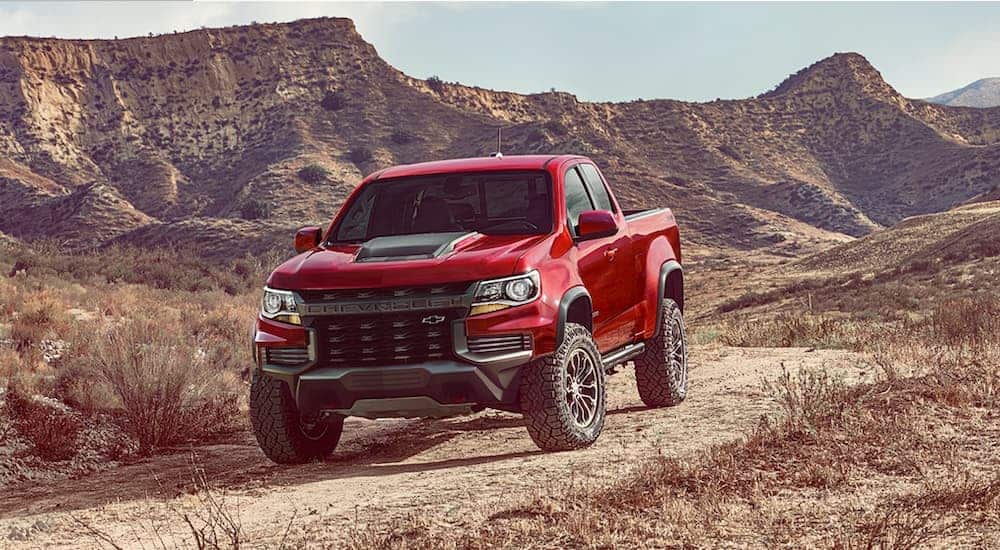 A red and black 2021 Chevy Colorado ZR2 is parked on a dirt path.