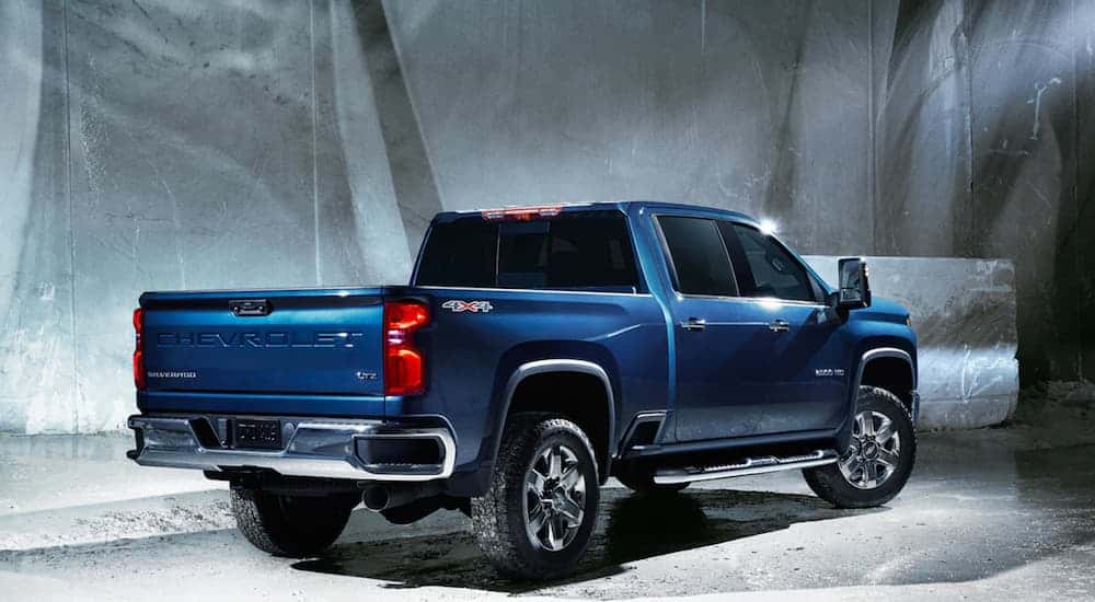 A blue 2021 Chevy Silverado 2500 HD LTZ is shown from behind with a concrete wall in the background.