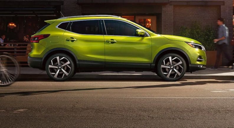 A bright green 2021 Nissan Rogue Sport is shown from the side, parked on the street.