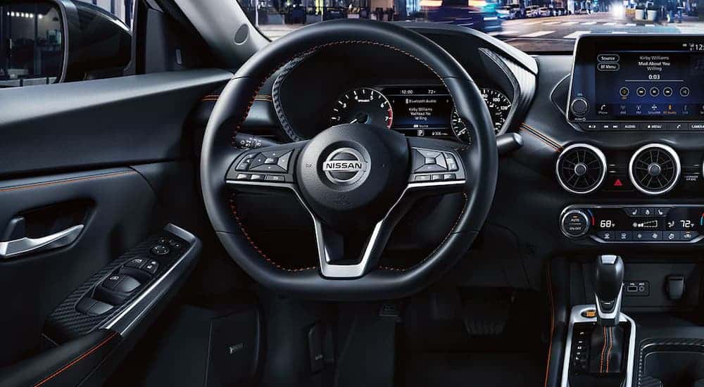 The black interior and steering wheel is shown in a 2021 Nissan Sentra.