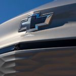 A close up shows the dark blue bowtie logo on a gray 2022 Chevy Bolt EUV.