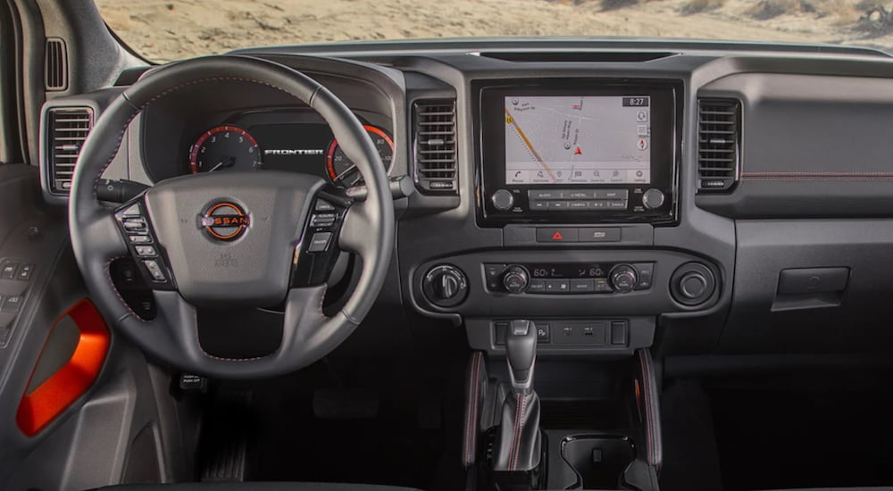 The steering wheel and infotainment screen is shown in a 2022 Nissan Frontier.